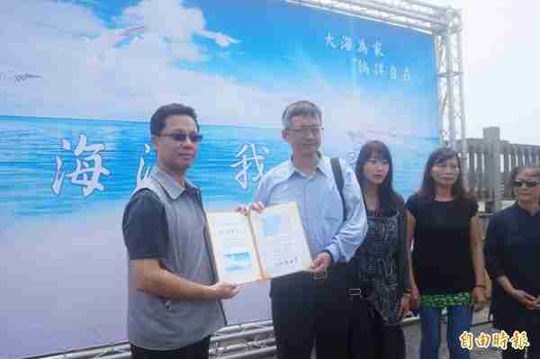 台中市生命禮儀管理處處長陳志銘（左）頒發海葬證書給家屬。（記者歐素美攝）