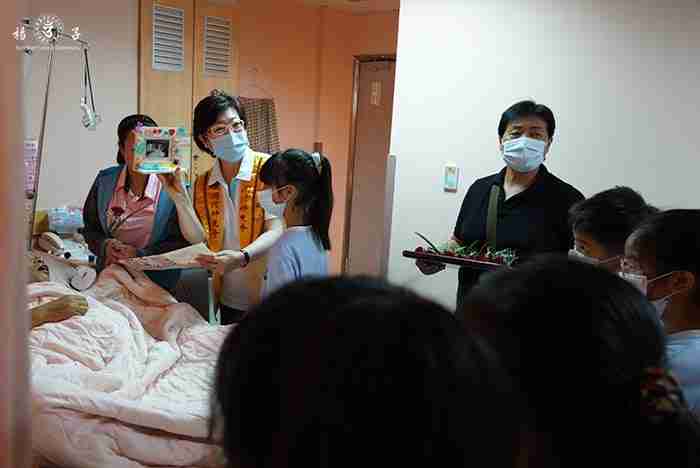 大小義工來到中榮安寧病房關懷病友，以浴佛活動邀病患結佛緣。佛光會資深義工孫娟娟老師右手拿著的，正是符師姐女兒親手為爸爸做的相框