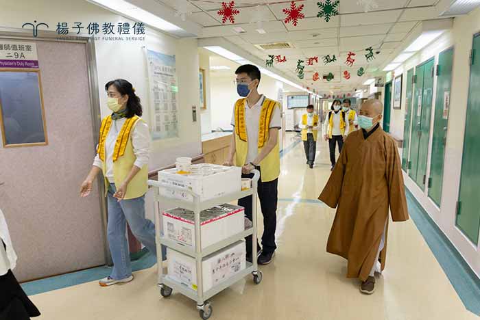 楊子同仁抵達台中榮總第二醫療大樓，與惠中寺覺清法師及佛光會督導們會合。分裝暖粥，展開這場連續 25 年的愛心接力。｜楊子佛教禮儀公司