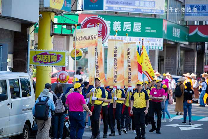 行腳祈福隊伍中的標語旗幟，書寫著「走出人間光明」的願心，引領人心向善 。｜楊子佛教禮儀