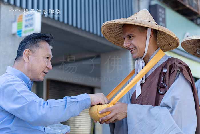 負責人楊子牧將供養投入法師缽中，祈願種下清淨福田與表達對僧眾續佛慧命的崇高敬意 。｜楊子佛教禮儀公司